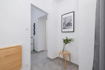 a hallway with a table with a vase on it at 1-Bedroom Apartment - Długa 65 Street in Kraków