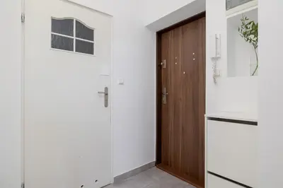 a kitchen with white walls and a wooden door at 1-Bedroom Apartment - Długa 65 Street in Kraków