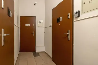 a hallway with two brown doors in a building at 1-Bedroom Apartment - Długa 65 Street in Kraków