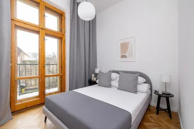 a bedroom with a bed and a large window at 2-Bedroom Apartment with Balcony - Długa 65 in Kraków