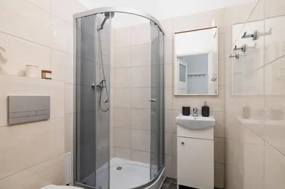 a bathroom with a shower and a toilet and a sink at 2-Bedroom Apartment with Balcony - Długa 65 in Kraków