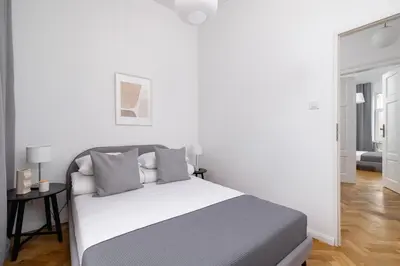 a white bedroom with a bed and a mirror at 2-Bedroom Apartment with Balcony - Długa 65 in Kraków