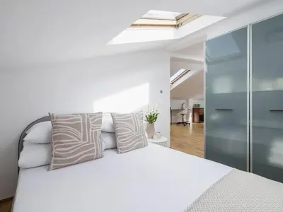 a bedroom with a white bed and a skylight at Studio apartment with AC - Długa 65 street in Kraków