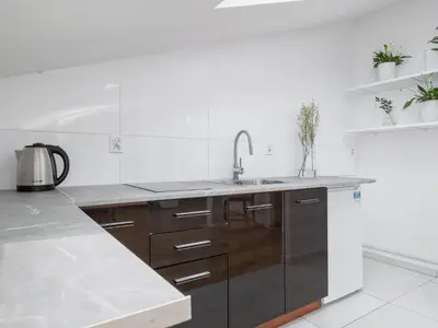 a white kitchen with a sink and a counter at Studio apartment with AC - Długa 65 street in Kraków