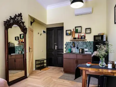 a living room with a table and a mirror at Yellow Studio - Kochanowskiego in Kraków
