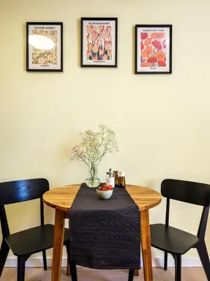 a dining room table with two chairs and a bowl of fruit on it at Yellow Studio - Kochanowskiego in Kraków