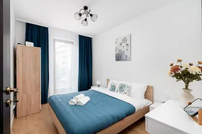 a bedroom with a bed with two towels on it at Przewóz Comfort Apartment by BookingHost in Kraków