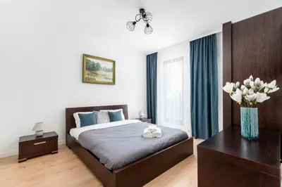 a bedroom with a bed and a vase of flowers at Przewóz Comfort Apartment by BookingHost in Kraków