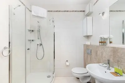 a bathroom with a shower and a toilet and a sink at Przewóz Comfort Apartment by BookingHost in Kraków