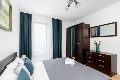 a bedroom with a bed and a dresser and a mirror at Przewóz Comfort Apartment by BookingHost in Kraków