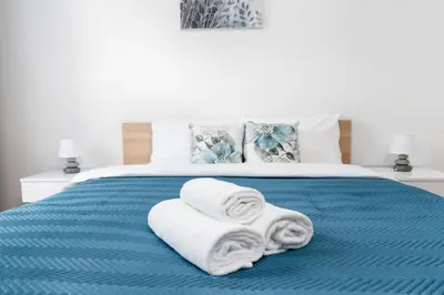 a bed with towels and pillows on it at Przewóz Comfort Apartment by BookingHost in Kraków