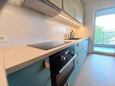 a kitchen with blue cabinets and a sink and a window at Old Town Apartments - Kącik 18 in Kraków