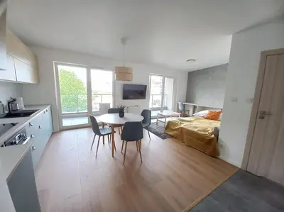 a kitchen and living room with a table and chairs at Old Town Apartments - Kącik 18 in Kraków