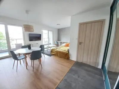 a room with a table and a bedroom with a bed at Old Town Apartments - Kącik 18 in Kraków