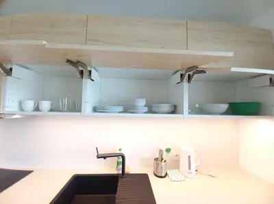 a kitchen with a sink and white cabinets with dishes at Old Town Apartments - Kącik 18 in Kraków