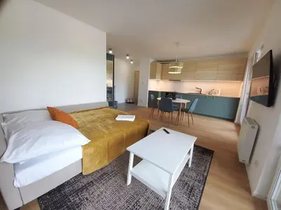 a bedroom with a bed and a table and a kitchen at Old Town Apartments - Kącik 18 in Kraków