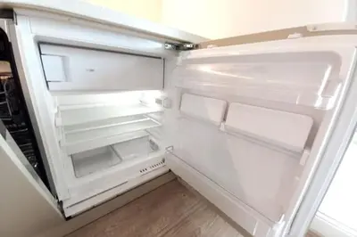 an empty refrigerator with its door open in a kitchen at Old Town Apartments - Kącik 60 in Kraków