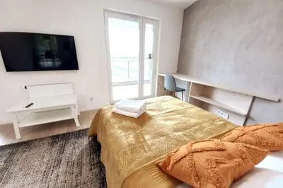 a bedroom with a large bed and a television at Old Town Apartments - Kącik 60 in Kraków