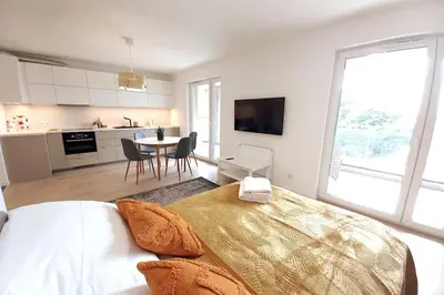 a bedroom with a large bed and a kitchen at Old Town Apartments - Kącik 60 in Kraków