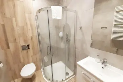 a bathroom with a shower and a toilet and a sink at Old Town Apartments - B42 in Kraków