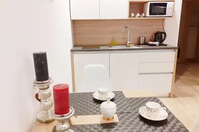 a kitchen with a table with two candles and a counter at Old Town Apartments - B42 in Kraków
