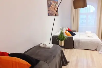 a living room with a bed and a lamp at Old Town Apartments - B42 in Kraków