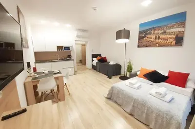 a living room with a bed and a dining room at Old Town Apartments - B42 in Kraków