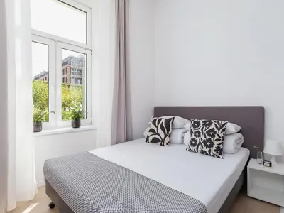 a white bedroom with a bed and two windows at Studio Apartment - Radziwiłłowska 27 in Kraków
