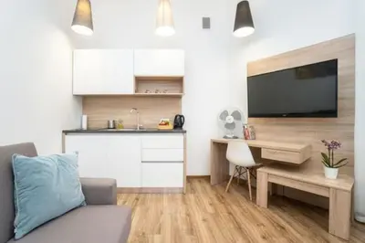 a living room with a couch and a desk with a television at Old Town Apartments - B22 in Kraków