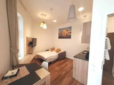 a room with a bed and a kitchen with a table at Old Town Apartments - B22 in Kraków