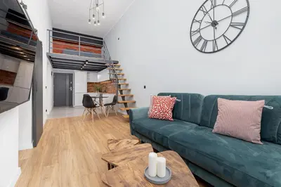 a living room with a green couch and a table at Modern Apartment in Kazimierz District - Józefa 2 in Kraków