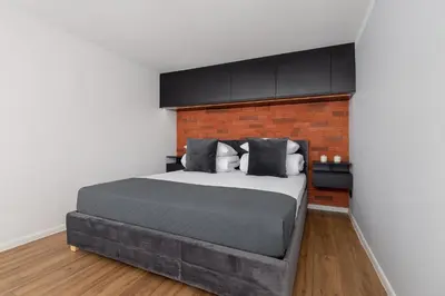 a bedroom with a large bed and a brick wall at Modern Apartment in Kazimierz District - Józefa 2 in Kraków
