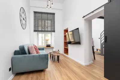 a living room with a blue couch and a television at Modern Apartment in Kazimierz District - Józefa 2 in Kraków