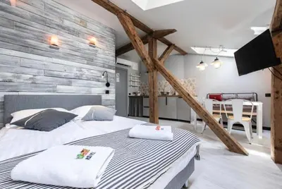 a bedroom with two beds and a dining room at Studio for two with an AC - Dietla 51 street in Kraków