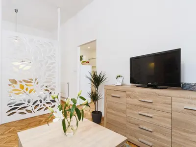 a living room with a flat screen tv on a dresser at 1 Bedroom Apartment - Starowiślna 54 in Kraków