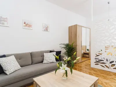 a living room with a couch and a table at 1 Bedroom Apartment - Starowiślna 54 in Kraków