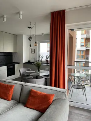 a living room with a couch and a kitchen with a table at Wrocławska 53 - Duży i Wygodny apartament in Kraków
