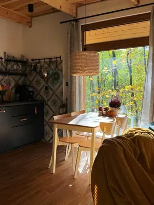 a dining table and chairs in a kitchen with a window at Rogaty Domek przy Bobrowisku in Kornatka