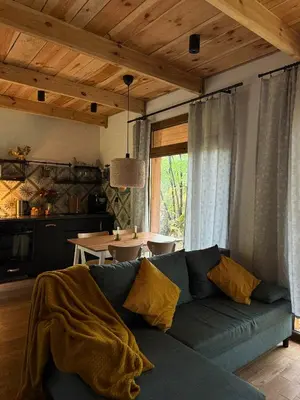 a living room with a blue couch and a table at Rogaty Domek przy Bobrowisku in Kornatka