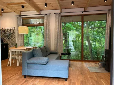 a living room with a blue couch and a table at Rogaty Domek przy Bobrowisku in Kornatka