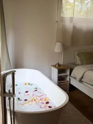a bath tub with flowers on it in a bedroom at Rogaty Domek przy Bobrowisku in Kornatka