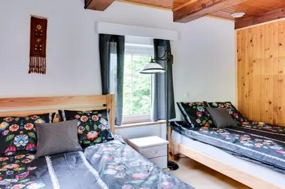 a bedroom with a bed with pillows and a window at Domek Jędrusiówka in Sułkowice