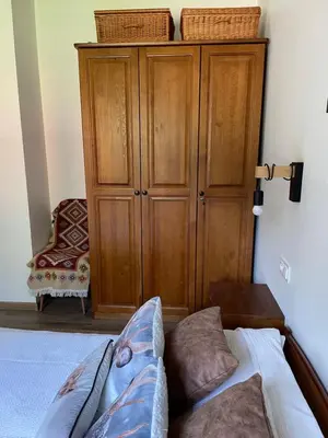 a bedroom with a bed and a wooden cabinet at Dom w górach - Jelenia Chata in Zawoja