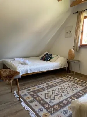 a bed in a room with a rug on the floor at Dom w górach - Jelenia Chata in Zawoja