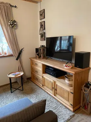 a living room with a television on a wooden entertainment center at Dom w górach - Jelenia Chata in Zawoja