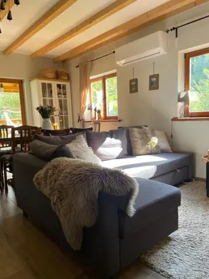 a living room with a blue couch with a blanket at Dom w górach - Jelenia Chata in Zawoja