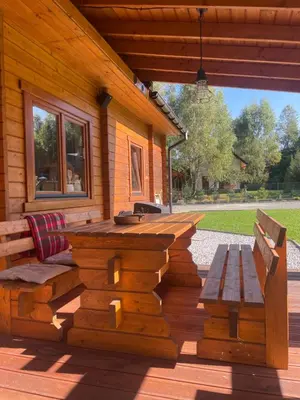 a patio with a table and benches on a house at Dom w górach - Jelenia Chata in Zawoja
