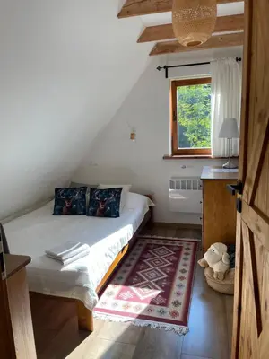 a bedroom with a bed and a window and a rug at Dom w górach - Jelenia Chata in Zawoja