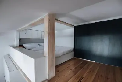 a bedroom with a white bed and a black wall at Apartment with mezzanine - Radziwiłłowska 27 in Kraków