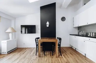 a kitchen with a table and chairs in a room at Apartment with mezzanine - Radziwiłłowska 27 in Kraków